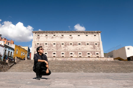 Man enjoying the travel experience near Alhondiga de Granaditas in Guanajuato, Mexico, under a cloudy skyの写真素材