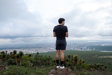 A man enjoying leisure in Cimatario Park, Queretaro, amidst clouds, trees, and highland terrain, creating a scenic adventureの写真素材