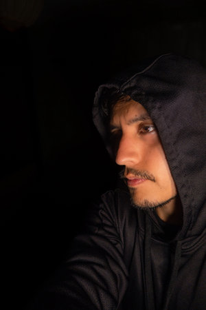 A Portrait of mexican man in sweatshirt and hat looking left with space for textの写真素材