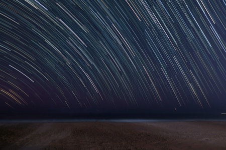 A Star trail on beach background with space for textの写真素材