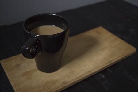 Coffee with milk on wooden table, on black wooden table with gray background.の写真素材