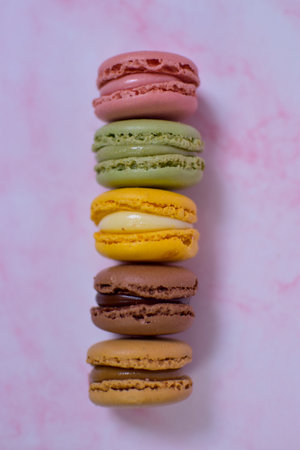 Colorful macarons stacked on pink marbleの写真素材