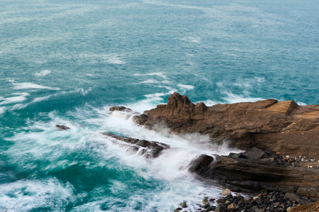 Long exposure of waves breaking over the rocksの写真素材
