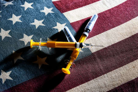 View of syringes above American flagの写真素材