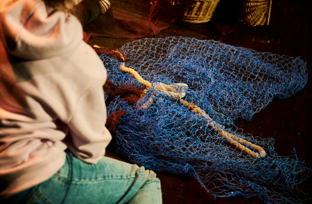 young woman repairing a fishing netのeditorial素材