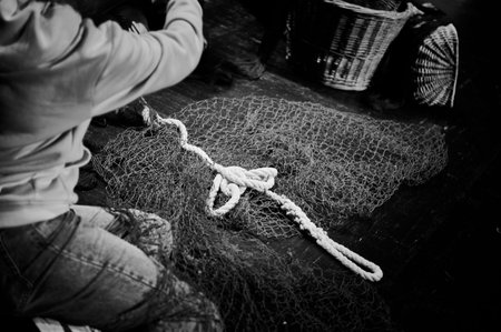 young woman repairing a fishing net
