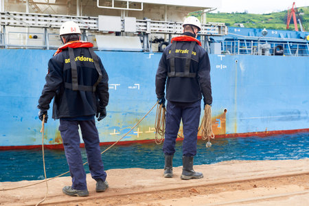 Two dockers mooring in charge ship in the port of Bilbao, Biscay, Basque Country, Euskadi, Spain,...