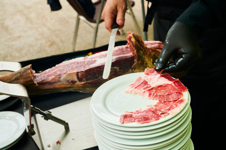 Hands of Master cutter cutting Iberian ham, Spainの写真素材