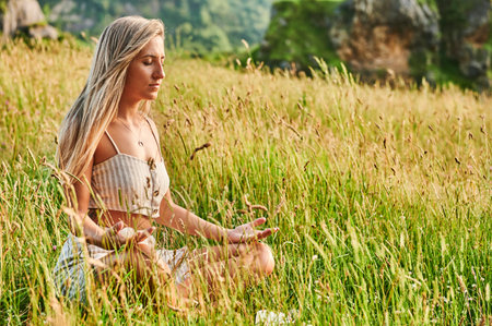 Blonde girl practicing meditation at dawnの写真素材