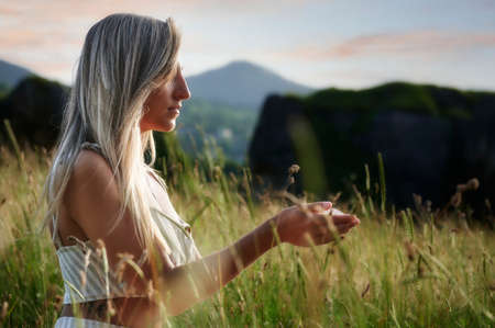 Blonde girl practicing meditation at dawnの写真素材