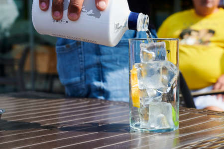 Detail of barkeeper serving a gin tonic in a terraceの写真素材