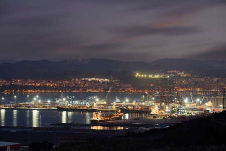 View of the port of Bilbao at dusk, Zierbena, Biscay, Basque Country, Euskadi, Spainの写真素材