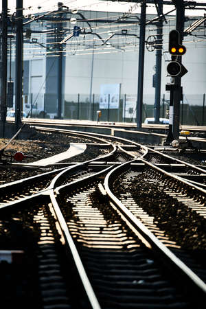 Railway crossing and traffic light in orange backlightの写真素材