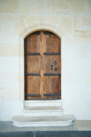 old wooden door with ironwork in a stone wallのeditorial素材