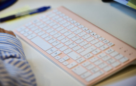 Modern white and pink computer keyboard on deskの写真素材