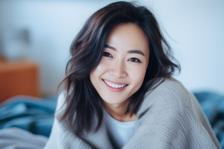 Smiling young Asian woman at homeの素材