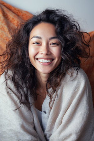 Smiling young Asian woman at homeの素材