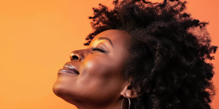 Close up of a confident middle aged woman with a peach copyspace backgroundの素材