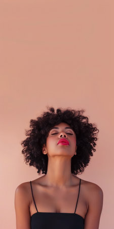 Close up of a confident young woman with a peach copyspace background for textの素材