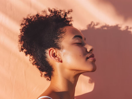 Close up of a confident young woman with a peach copyspace background for textの素材