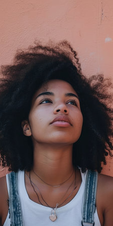Close up of a confident young woman with a peach copyspace background for textの素材