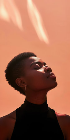 Close up of a confident young woman with a peach copyspace background for textの素材