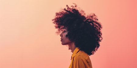 Close up of a confident young woman with a peach copyspace background for textの素材