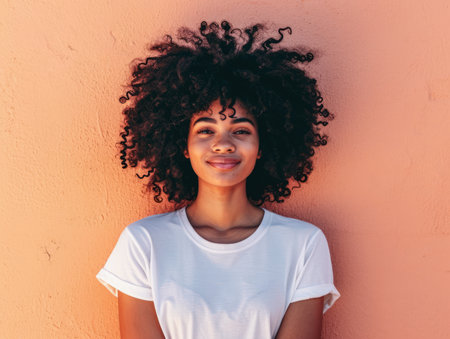 Close up of a confident young woman with a peach copyspace background for textの素材