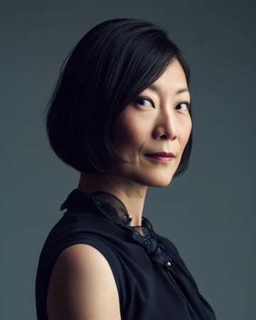 Seasoned Asian businesswoman portrait looking confident on a color copy space backgroundの素材
