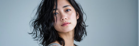 Beauty portrait of a natural young Japanese woman with a soft grey copy space backgroundの素材