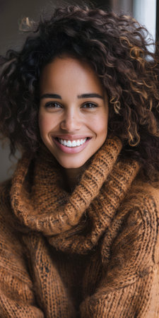 Young woman with curly hair and a cozy sweater. Warm tones composition.の素材
