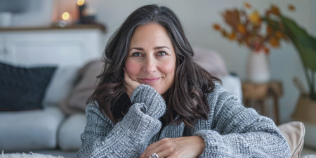 Portrait of a young beautiful woman at home wearing a cozy knitwearの素材
