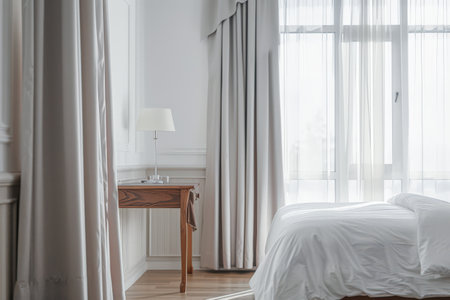 Modern hotel room with elegant bedding and stylish decor. Neutral tones and use of natural light.の素材