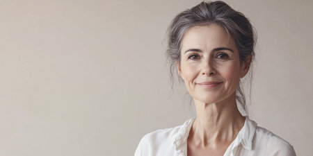 Middle aged woman smiling isolated from a copyspace background. Inclusivity conceptual imageの素材