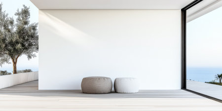Two round poufs rest on a wooden floor, surrounded by a spacious white wall and large glass windows revealing a tranquil water view under afternoon light.の素材
