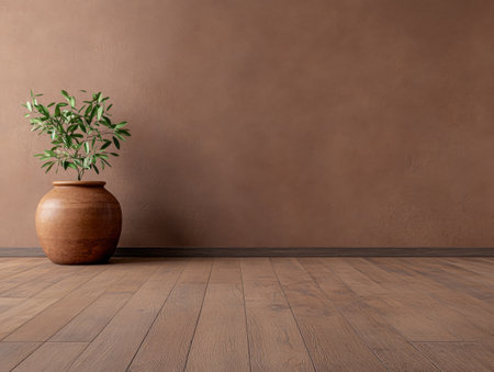 A clay pot filled with lush green foliage stands on wooden flooring next to a warm brown wall, creating a serene, inviting atmosphere in the interior.の素材
