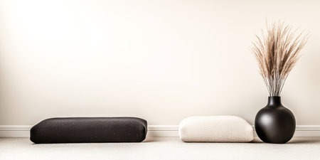 In a serene space, two decorative cushions sit side by side, accompanied by a sleek black vase holding dried pampas grass, enhancing the minimalist decor.の素材