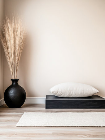 A minimalist meditation corner showcases a black platform with a soft pillow, accompanied by elegant dried flowers in a vase, creating a calming atmosphere.の素材