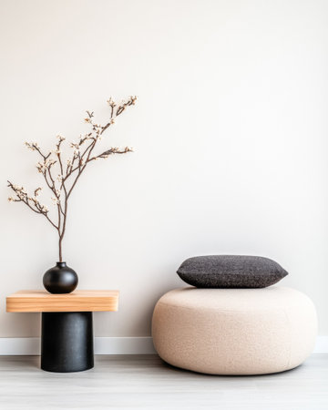 A stylish and minimalist interior showcases a soft, round ottoman beside a wooden side table. The table holds a vase with dried flowers, enhancing the serene ambiance.の素材