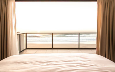 A serene view of the ocean at sunrise from a hotel room, with delicate curtains framing the balcony and waves gently lapping at the shore.の素材