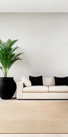A stylish living room features a spacious white sofa adorned with black pillows, complemented by a tall potted plant against a simple background, creating a serene ambiance.の素材
