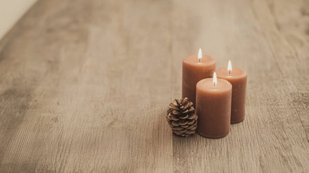 Three brown candles flicker gently beside a pine cone, casting a warm glow. The setting is intimate, perfect for relaxation in a calm evening atmosphere.の素材