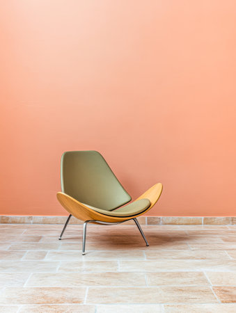 A stylish lounge chair featuring a green seat and wooden base is positioned against a warm peach wall with a light stone floor, creating a contemporary and inviting atmosphere.の素材