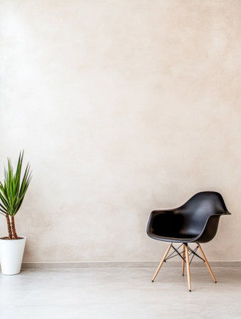 A stylish, minimalist room showcases a black chair positioned beside a tall potted plant against a smooth, light-colored wall, creating a serene atmosphere.の素材