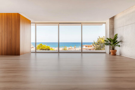 A spacious, minimally designed room showcases large glass windows that frame a stunning ocean view under natural daylight. The warm wooden accents contrast with soft concrete.の素材