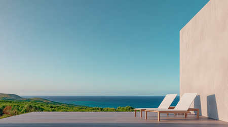 A minimalist outdoor lounge features two sun loungers placed on a deck, with a stunning view of the ocean and lush greenery under a clear blue sky. Ideal for relaxation and enjoying nature.の素材