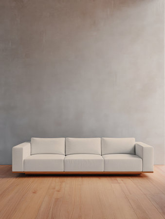 A sleek, modern sofa occupies a well-lit room with light wooden flooring and a plain neutral wall. The design emphasizes simplicity and comfort, inviting relaxation.の素材