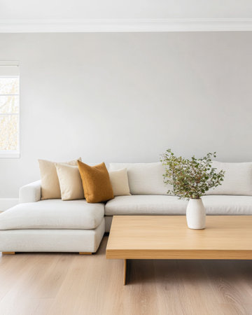 The relaxing living room features a light-colored sofa adorned with decorative pillows, a simple wooden coffee table, and a fresh plant in a vase, creating a serene atmosphere for gatherings.の素材