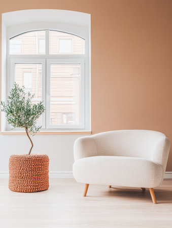 A stylish living room corner features a curvy white couch beside a decorative woven basket housing a small tree. Sunlight filters through the window, enhancing the warm ambiance.の素材