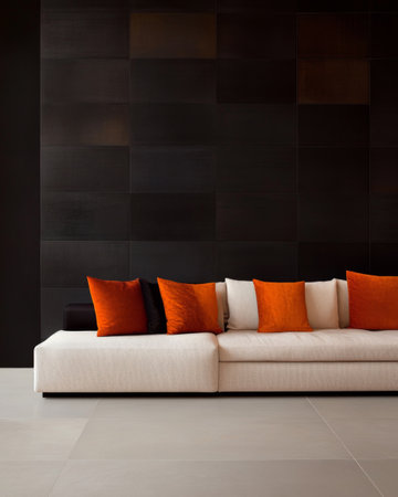 A contemporary living room features a sleek white sofa adorned with vivid orange cushions, set against a rich black wall, creating a striking contrast in design and color.の素材